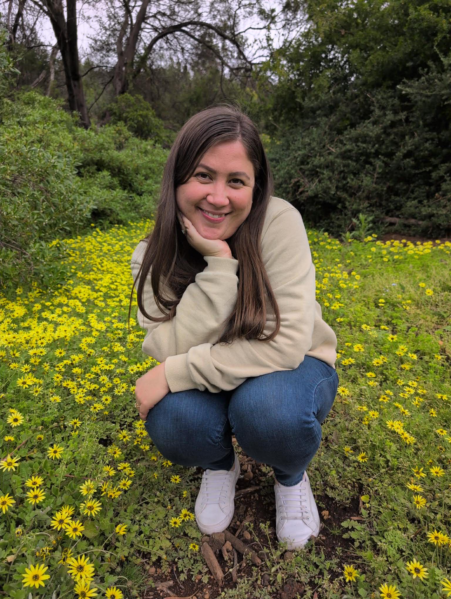 Nanita sitting cross-legged with a singing bowl, surrounded by sunflowers and candles